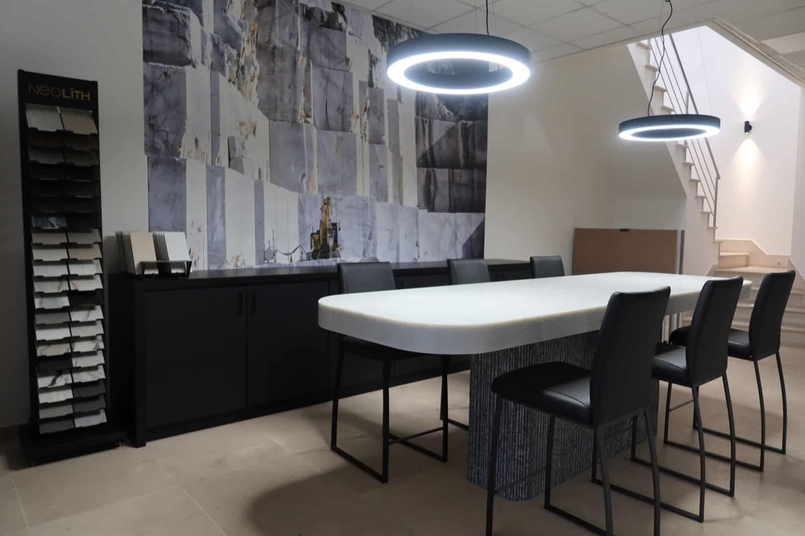 Showroom met een natuurstenen tafel, stalen van werkbladen en een wand met een groevefoto
